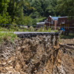 
              A section of road along KY-3351 near a bridge over Troublesome Creek near Ary in Perry County, Ky., remains damaged Tuesday, Aug. 2, 2022, following flooding last week that devastated many counties in Eastern Kentucky. (Ryan C. Hermens/Lexington Herald-Leader via AP)
            