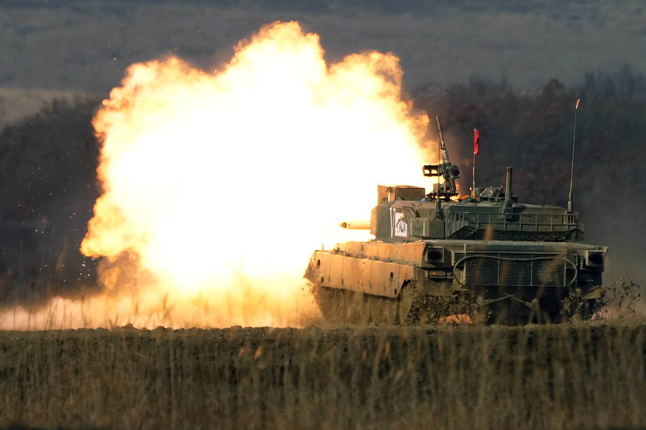 FILE - A Japanese Ground-Self Defense Force (JGDDF) Type 90 tank fires its gun while advancing towa...