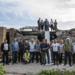 
              Volunteers pose for a group photo in front of of Zhanna and Serhiy Dynaeva's house which was destroyed by Russian bombardment, in the village of Novoselivka, near Chernihiv, Ukraine, Saturday, Aug. 13, 2022. Residents in many heavily-damaged areas in Ukraine have set up their own initiatives to rebuild homes before the winter as international organizations rush aid to Ukraine to help with the reconstruction effort. (AP Photo/Evgeniy Maloletka)
            