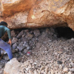 
              Community member tries to peep through a half closed shaft that was used by illegal miners in Krugersdorp Johannesburg, South Africa, Thursday, Aug. 4, 2022. Community members in the South African city of Krugersdorp beat suspected illegal miners with sticks and set fire to their camps on Thursday in an outpouring of anger following the alleged gang rapes of eight women last week by more than 80 men suspected of being miners. (AP Photo/Themba Hadebe)
            