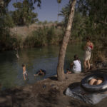 
              People spend the day at the Jordan River near Kibbutz Kinneret in northern Israel on Saturday, July 30, 2022. Environmental group EcoPeace Middle East has been urging regional collaboration on the Jordan between rivals who have long had every motivation to squeeze as much water as possible out of the river or its tributaries. (AP Photo/Oded Balilty)
            