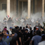 
              Iraqi security forces fire tear gas on the followers of Shiite cleric Muqtada al-Sadr inside the government Palace, Baghdad, Iraq, Monday, Aug. 29, 2022. Al-Sadr, a hugely influential Shiite cleric announced he will resign from Iraqi politics and his angry followers stormed the government palace in response. The chaos Monday sparked fears that violence could erupt in a country already beset by its worst political crisis in years. (AP Photo/Hadi Mizban)
            
