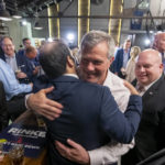 
              Michigan gubernatorial candidate Kevin Rinke hugs supporters during an election night party at The Dow at Dick O' Dow's, in Birmingham, Mich., Tuesday, Aug. 2, 2022. (David Guralnick/Detroit News via AP)
            