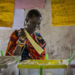 
              A Maasai woman casts her vote at a polling station in Esonorua Primary School, in Kajiado County, Kenya Tuesday, Aug. 9, 2022. Polls opened Tuesday in Kenya's unusual presidential election, where a longtime opposition leader who is backed by the outgoing president faces the deputy president who styles himself as the outsider. (AP Photo/Ben Curtis)
            