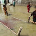 
              Children salvage a cot from their flood-hit home, in Charsadda, Pakistan, Wednesday, Aug. 31, 2022. Officials in Pakistan raised concerns Wednesday over the spread of waterborne diseases among thousands of flood victims as flood waters from powerful monsoon rains began to recede in many parts of the country. (AP Photo/Mohammad Sajjad)
            