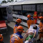 
              Olaya Chacon, of Venezuela, is carried by Colombian paramedics onto an ambulance, to be treated off a broken leg in Colombia, on the Simon Bolivar international bridge in Villa del Rosario, near Cucuta, on Colombia's border with Venezuela, Sunday, Aug. 7, 2022. Colombia's incoming foreign minister and his Venezuelan counterpart announced in late July that the border, partially closed since 2015, will gradually reopen after the two nations restore diplomatic ties when Colombia's new president is sworn-in on Aug. 7. (AP Photo/Matias Delacroix)
            
