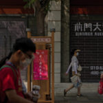 
              Visitors wearing face masks tour past vacant shop lots at Qianmen Street in Beijing, Wednesday, Aug. 17, 2022. Factories in China's southwest have shut down after reservoirs used to generate hydropower ran low in a worsening drought, adding to economic strains at a time when President Xi Jinping is trying to extend his position in power. (AP Photo/Andy Wong)
            