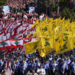 
              Lebanese Shiite scouts of the Iranian-backed Hezbollah group carry their group and Lebanese flags as they march during the holy day of Ashoura that commemorates the 7th century martyrdom of the Prophet Muhammad's grandson Hussein, in the southern suburb of Beirut, Lebanon, Tuesday, Aug. 9, 2022. The leader of Lebanon's Hezbollah group Sheikh Hassan Nasrallah warned archenemy Israel on Tuesday over the two countries' maritime border dispute. (AP Photo/Hussein Malla)
            