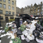 
              A view of overflowing bins in the Grassmarket area of Edinburgh where cleansing workers from the City of Edinburgh Council are on the fourth day of eleven of strike action, in Scotland, Wednesday, Aug. 24, 2022. Workers at waste and recycling depots across the city have rejected a formal pay offer of 3.5 percent from councils body Cosla. (Andrew Milligan/PA via AP)
            