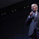 
              President Joe Biden speaks to a crowd in a overflow room at a rally hosted by the Democratic National Committee at Richard Montgomery High School, Thursday, Aug. 25, 2022, in Rockville, Md. (AP Photo/Evan Vucci)
            