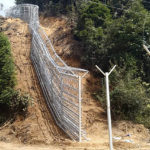 
              This early 2022 photo provided by Global Witness shows a border fence separating Pangwa in the Kachin state of Myanmar and China. Rare earths imports from Myanmar grew nearly a hundredfold in just the three years since 2015. By 2018, they made up nearly three-fourths of China’s heavy rare-earth-rich clay ore supply, according to the latest statistics available. (Global Witness via AP)
            