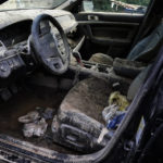 
              A car is filled with dry mud in the aftermath of massive flooding, Tuesday, Aug. 2, 2022, in Hindman, Ky. (AP Photo/Brynn Anderson)
            