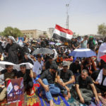 
              Supporters of the Shiite cleric Muqtada al-Sadr hold prayer near the parliament building in Baghdad, Iraq, Friday, Aug. 12, 2022. Al-Sadr's supporters continue their sit-in outside the parliament to demand early elections. The photo show Muqtada al-Sadr. (AP Photo/Anmar Khalil)
            