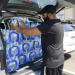 
              Rajwinder Singh, a gas station/convenience store owner, pats into place the 15 cases of drinking water he purchased from a Kroger grocery store into his vehicle, Tuesday, Aug. 30, 2022, in Jackson, Miss. Parts of Jackson were without running water Tuesday because recent flooding worsened problems in one of two water-treatment plants as part of the city's response to longstanding water system problems. The state Health Department put Mississippi's capital city under a boil-water notice in late July. (AP Photo/Rogelio V. Solis)
            