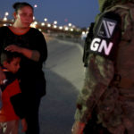 
              FILE - A National Guardsman detains Guatemalan migrants at the Mexico-U.S. border in Ciudad Juarez, Mexico, June 24, 2019. Mexico’s President Andres Manuel Lopez Obrador has begun exploring plans to side-step congress to hand formal control of the National Guard to the army. That has raised concerns, because he won approval for creating the force in 2019 by pledging in the constitution that it would be under nominal civilian control and that the army would be off the streets by 2024.  (AP Photo/Christian Chavez, File)
            