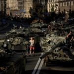 
              People walk around destroyed Russian military vehicles installed in downtown Kyiv, Ukraine, Wednesday, Aug. 24, 2022. Kyiv authorities have banned mass gatherings in the capital through Thursday for fear of Russian missile attacks. Independence Day, like the six-month mark in the war, falls on Wednesday. (AP Photo/Evgeniy Maloletka)
            