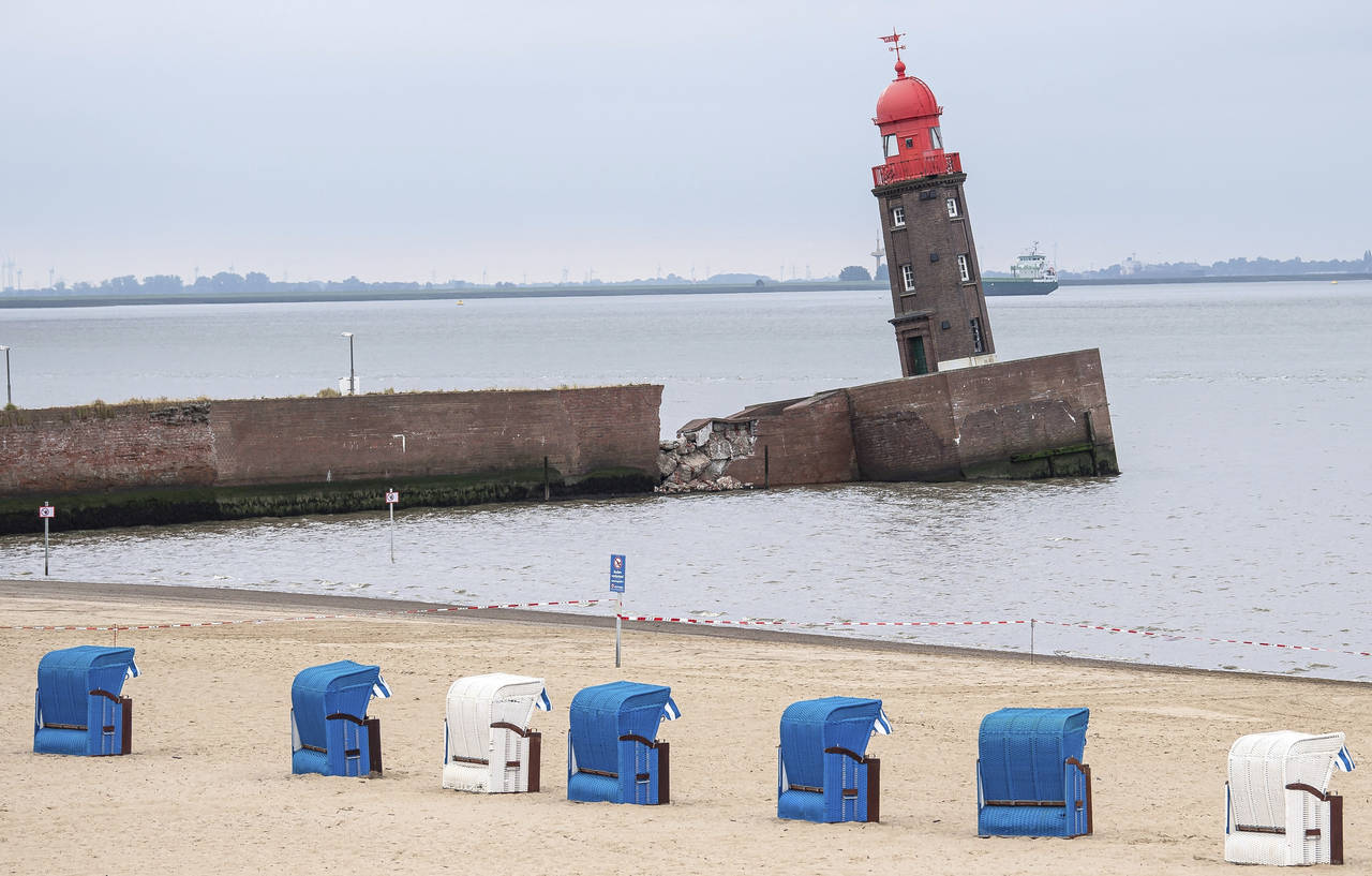 Beach chairs stay on the beach next to the leaning Mole tower in Bremerhaven, Germany, Thursday, Au...