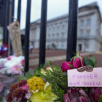 
              Flowers and a message are seen outside Buckingham Palace, rear, in London, Friday, Sept. 9, 2022. Queen Elizabeth II, Britain's longest-reigning monarch and a rock of stability across much of a turbulent century, died Thursday Sept. 8, 2022, after 70 years on the throne. She was 96. (AP Photo/Kirsty Wigglesworth)
            