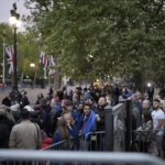 
              People wait to get access to The Mall to watch the funeral procession of Queen Elizabeth II in London, Monday, Sept. 19, 2022. The Queen, who died aged 96 on Sept. 8, will be buried at Windsor alongside her late husband, Prince Philip, who died last year. (AP Photo/Markus Schreiber)
            