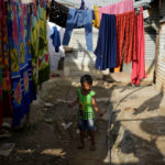 
              A child plays with a jump rope in a narrow lane of a poor neighborhood in Bengaluru, India, Tuesday, July 19, 2022. In this community, most people are from Assam state, many forced to migrate because of climate change and dreaming of a better future. (AP Photo/Aijaz Rahi)
            