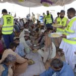 
              Volunteers of a charity group distribute food to flood victims, in Jaffarabad, a flood-hit district of Baluchistan province, Pakistan, Thursday, Sept. 15, 2022. The devastating floods affected over 33 million people and displaced over half a million people who are still living in tents and make-shift homes. The water has destroyed 70% of wheat, cotton and other crops in Pakistan. (AP Photo/Zahid Hussain)
            