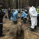 
              EDS NOTE: GRAPHIC CONTENT - Emergency workers move a body during an exhumation in the recently retaken area of Izium, Ukraine, Friday, Sept. 16, 2022. Ukrainian authorities discovered a mass burial site near the recaptured city of Izium that contained hundreds of graves. It was not clear who was buried in many of the plots or how all of them died, though witnesses and a Ukrainian investigator said some were shot and others were killed by artillery fire, mines or airstrikes. (AP Photo/Evgeniy Maloletka)
            