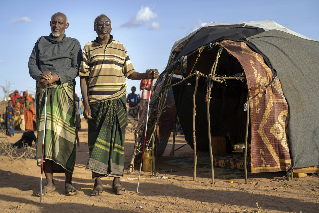 Mohamed Kheir Issack, 80, right, and and Issack Farow Hassan, 75, stand outside Issack's shelter at...