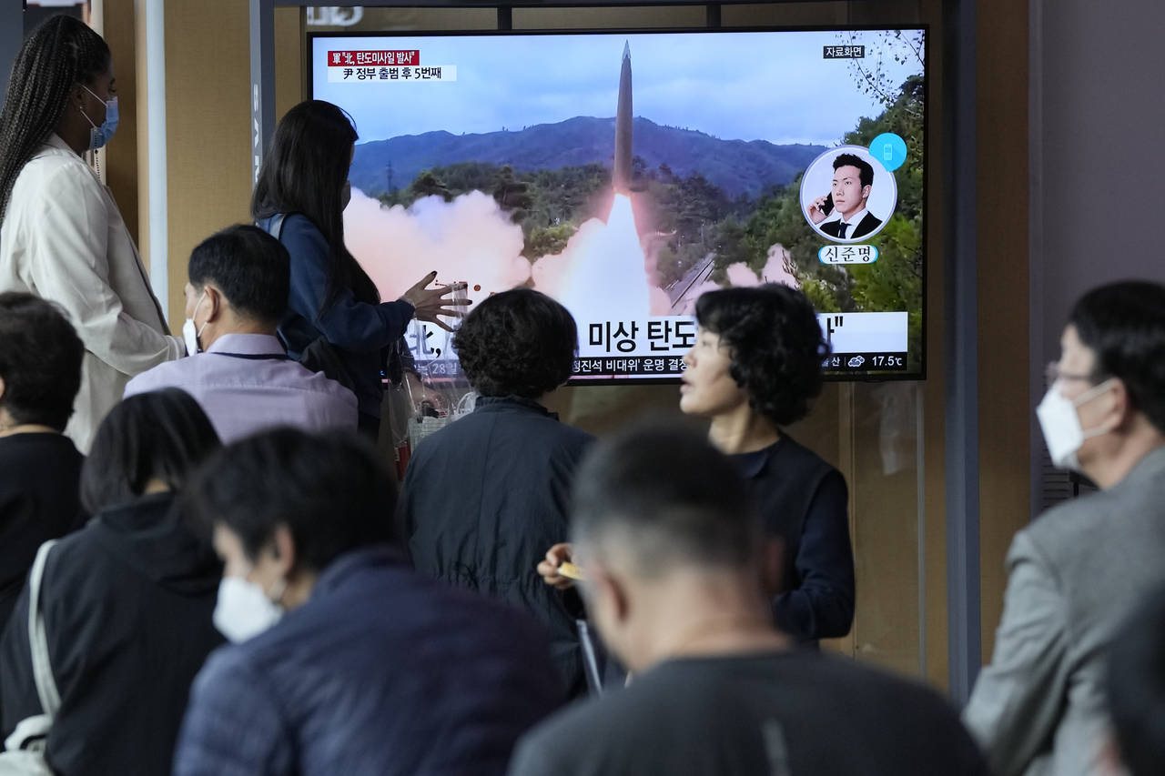 People watch a news program showing a file image of a missile launch by North Korea at the Seoul Ra...