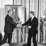 
              FILE - President Jimmy Carter shakes hands with former President Gerald R. Ford in the White House in Washington on May 24, 1978 during a ceremony at which a portrait of the former Chief Executive was unveiled. (AP Photo, File)
            