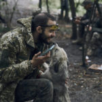 
              A Ukrainian soldier plays with a dog as he has a rest in the freed territory in the Kharkiv region, Ukraine, Monday, Sept. 12, 2022. Ukrainian troops retook a wide swath of territory from Russia on Monday, pushing all the way back to the northeastern border in some places, and claimed to have captured many Russian soldiers as part of a lightning advance that forced Moscow to make a hasty retreat. (AP Photo/Kostiantyn Liberov)
            