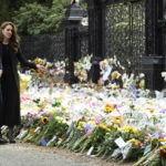 
              Britain's William, Prince of Wales, left and Kate, Princess of Wales, look at floral tributes left by members of the public, in memory of late Queen Elizabeth II, at the Sandringham Estate, in Norfolk, England, Thursday, Sept. 15, 2022.  Queen Elizabeth II, Britain's longest-reigning monarch died Thursday Sept. 8, 2022, after 70 years on the throne. (Toby Melville/Pool via AP)
            