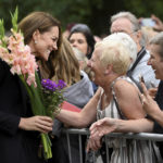
              Kate, Princess of Wales reacts with a well-wisher as she and Prince William, view floral tributes left by members of the public, in memory of late Queen Elizabeth II, at the Sandringham Estate, in Norfolk, England, Thursday, Sept. 15, 2022.  Queen Elizabeth II, Britain's longest-reigning monarch died Thursday Sept. 8, 2022, after 70 years on the throne. (Toby Melville/Pool via AP)
            
