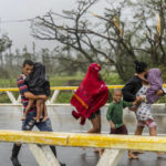 
              A family walks in the rain after Hurricane Ian hit Pinar del Rio, Cuba, Tuesday, Sept. 27, 2022. Ian made landfall at 4:30 a.m. EDT Tuesday in Cuba’s Pinar del Rio province, where officials set up shelters, evacuated people, rushed in emergency personnel and took steps to protect crops in the nation’s main tobacco-growing region. (AP Photo/Ramon Espinosa)
            