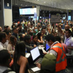 
              Passenger try to reschedule their flights after many were cancelled or delayed due to Hurricane Ian, at Tocumen International Airport in Panama City, Tuesday, Sept. 27, 2022. Hurricane Ian tore into western Cuba as a major hurricane and left 1 million people without electricity, then churned on a collision course with Florida over warm Gulf waters amid expectations it would strengthen into a catastrophic Category 4 storm. (AP Photo/Matias Delacroix)
            