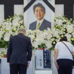 
              People leave flowers and pay their respects to former Japanese Prime Minister Shinzo Abe outside the Nippon Budokan in Tokyo Tuesday, Sept. 27, 2022, ahead of his state funeral later in the day. (Nicolas Datiche/Pool Photo via AP)
            