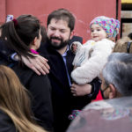 
              Chile's President Gabriel Boric, center, holds a baby as he embraces a supporter outside a polling station during a plebiscite on a new draft of the Constitution in Punta Arenas, Chile, Sunday, Sept. 4, 2022. Chileans are deciding if they will replace the current Magna Carta imposed by a military dictatorship 41 years ago. (AP Photo/Andres Poblete)
            