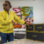 
              Shekar Natarajan, chief supply chain officer at retailer American Eagle Outfitters, demonstrates how a consumer would use 'Tag Along,' a modular, collapsible shipping box system in the office of Berns Communications Group on Friday, Aug. 5, 2022, in New York. Since Natarajan joined American Eagle nearly four years ago, the teen retailer has purchased two supply chain businesses and he has begun building a logistics platform that other retailers including rivals can share. So far, more than 80 retailers have signed on. This modular, collapsible shipping box system that the company is developing, could be used to ship items from multiple brands to a customer's home. The goal is to reduce shipping time and costs for retailers and better compete with the likes of Amazon and Walmart. (AP Photo/Brittainy Newman)
            