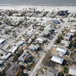 
              This aerial photo shows damaged homes and debris in the aftermath of Hurricane Ian, Thursday, Sept. 29, 2022, in Fort Myers, Fla. (AP Photo/Wilfredo Lee)
            