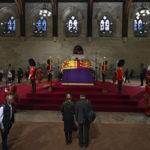 
              Members of the public file past the coffin of Queen Elizabeth II, inside Westminster Hall, at the Palace of Westminster, in London Wednesday, Sept. 14, 2022, where it Lies in State on a Catafalque. Queen Elizabeth II will lie in state in Westminster Hall inside the Palace of Westminster, from Wednesday until a few hours before her funeral on Monday, with huge queues expected to file past her coffin to pay their respects.  (Ben Stansall/Pool Photo via AP)
            