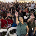 
              Attendees raise their hands as they worship inside the tent during the ReAwaken America tour at Cornerstone Church, in Batavia, N.Y., Friday, Aug. 12, 2022. Speaking at the event, Michael Flynn, former national security adviser to former President Donald Trump, is trying to build a movement centered on Christian nationalist ideas, where Christianity is at the center of American life and institutions. (AP Photo/Carolyn Kaster)
            