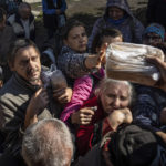 
              Local residents receive humanitarian aid distributed by volunteers in the recently retaken area of Izium, Ukraine, Wednesday, Sept. 21, 2022. (AP Photo/Evgeniy Maloletka)
            