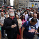 
              People gather on Cedar Street by the perimeter of the commemoration ceremony during a moment of silence on the 21st anniversary of the September 11, 2001 terror attacks on Sunday, Sept. 11, 2022 in New York. (AP Photo/Stefan Jeremiah)
            