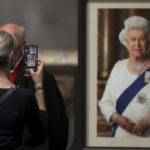 
              A woman takes a picture after the Service of Prayer and Reflection, following the passing of Britain's Queen Elizabeth II, at St Paul's Cathedral in London, Friday Sept. 9, 2022. (Paul Childs/Pool Photo via AP)
            