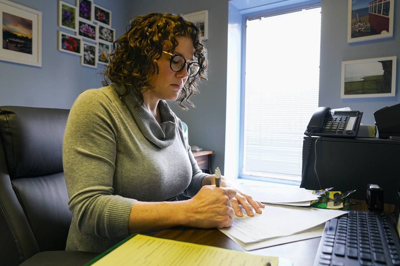 Dr. Katie McHugh, an obstetrician-gynecologist, looks over abortion content forms as she works at t...