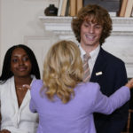 
              First lady Jill Biden embraces Winslow Hastie, Jr., from Charleston, S.C., during an event for the Class of 2022 National Student Poets at the White House in Washington Tuesday, Sept. 27, 2022. At left is Emily Igwike, from Milwaukee. (AP Photo/Carolyn Kaster)
            