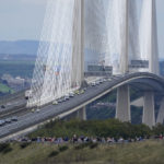 
              The hearse carrying the coffin of Queen Elizabeth II, draped with the Royal Standard of Scotland, passing over the Queensferry Crossing in Scotland, Sunday, Sept. 11, 2022, as it continues its journey to Edinburgh from Balmoral. (Owen Humphreys/PA via AP)
            