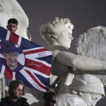 
              Mourners on Queen Victoria Memorial outside Buckingham Palace in central London, following the announcement of the death of Queen Elizabeth II, Thursday, Sept. 8, 2022. Britain's longest-reigning monarch and a rock of stability across much of a turbulent century, has died. She was 96. (Yui Mok/PA via AP)
            