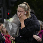 
              A mourner puts flowers at the gates of Buckingham Palace in London, Friday, Sept. 9, 2022. Queen Elizabeth II, Britain's longest-reigning monarch and a rock of stability across much of a turbulent century, died Thursday Sept. 8, 2022, after 70 years on the throne. She was 96. (AP Photo/Kirsty Wigglesworth)
            