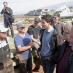 
              Canadian Prime Minister Justin Trudeau speaks speaks with Mitch Jollimore, left, lobster fisherman and business owner of Stanley's fish and chips and Basin View Seafood  as he visits Stanley Bridge, Prince Edward Island, Tuesday, Sept. 27, 2022, to see the damage done by post-tropical storm Fiona.  (Brian McInnis/The Canadian Press via AP)
            