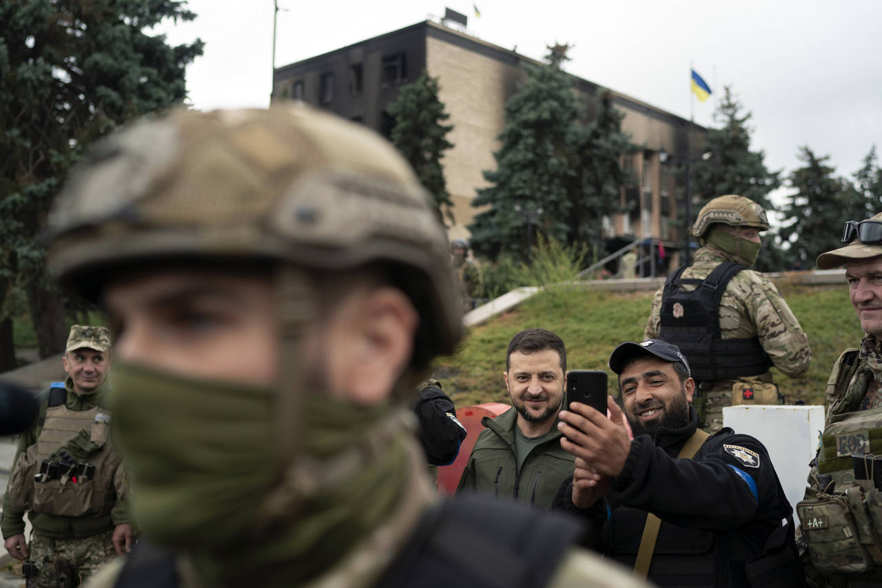Ukrainian President Volodymyr Zelenskyy poses for a selfie with a police officer after attending a ...